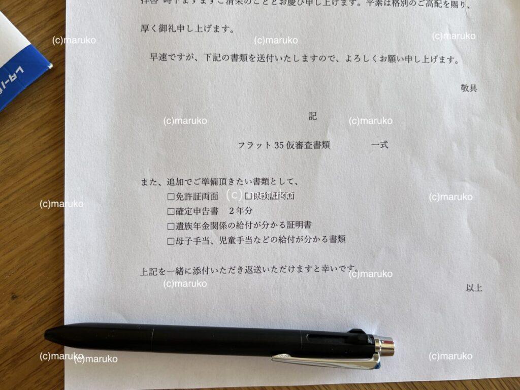 住宅ローン仮審査で金融機関から送られてきた、こちらで準備する書類の案内文。必要書類のチェックリストが記載された用紙とペンが机に置かれている様子