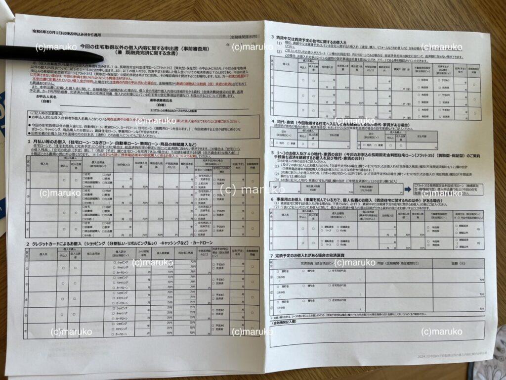 住宅ローン仮審査の申込書2枚目。収入・借入状況・返済計画などを記入する欄がある金融機関指定の書類が広げられている様子