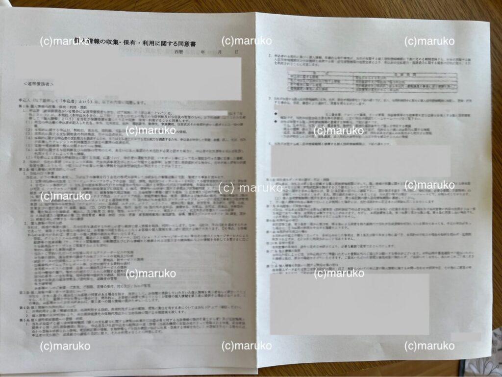 住宅ローン仮審査の同意書2枚目。信用情報の照会や提供に関する項目が記載された書類が広げられている様子